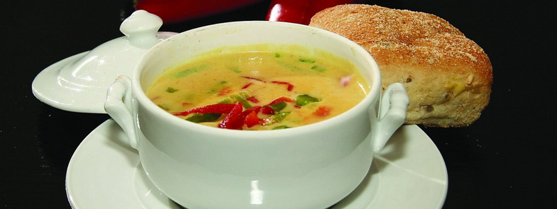 A bowl of soup and a bread roll